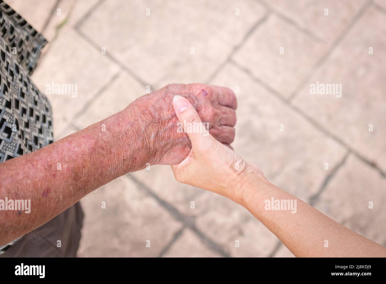 Frau hält die Hand eines älteren Mannes. Pflege für ältere Menschen Konzept. Stockfoto