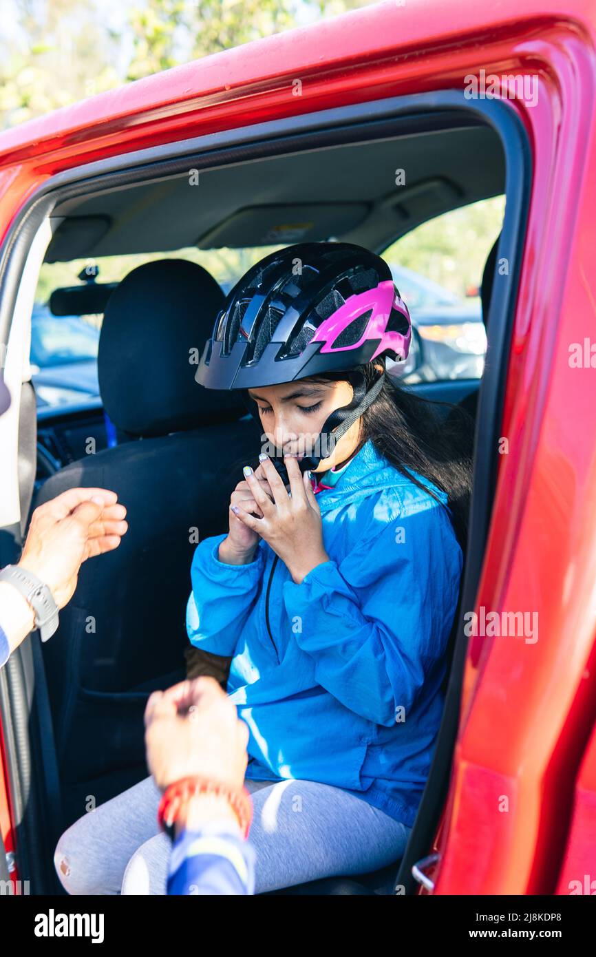Mädchen, die einen Schutzhelm aufsetzen, um Sport in einem Fahrzeug zu treiben Stockfoto