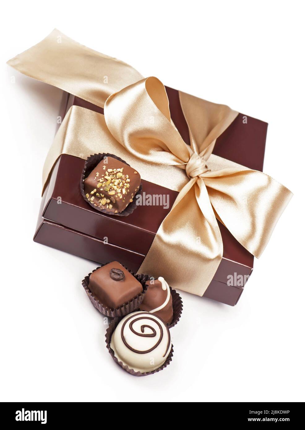 Braune Schachtel mit Bonbons und goldenem Klebeband isoliert auf dem weißen Stockfoto