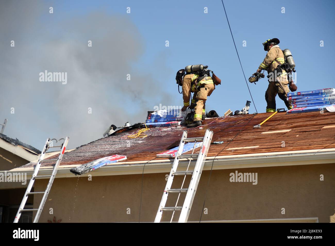 Ein Hausbrand im Stadtteil Kearny Mesa von San Diego führte zu einem ersten Alarmeinsatz der Feuerwehr von San Diego. Das sich schnell bewegende Feuer zerstörte den Wohnteil des Hauses, wobei nur die Garage die Flammen überlebte. Nach einem vollständigen Dacheinsturz über den Wohnräumen mussten die Feuerwehrleute eine Luftleiter verwenden, um die Flammen zu löschen. Die beiden Bewohner des Hauses entkamen unverletzt. Die Ursache des Feuers wurde durch die jüngsten Arbeiten am Dach der Konstruktion bestimmt und der Gesamtschadens wurde auf $400.000 USD festgesetzt. Stockfoto