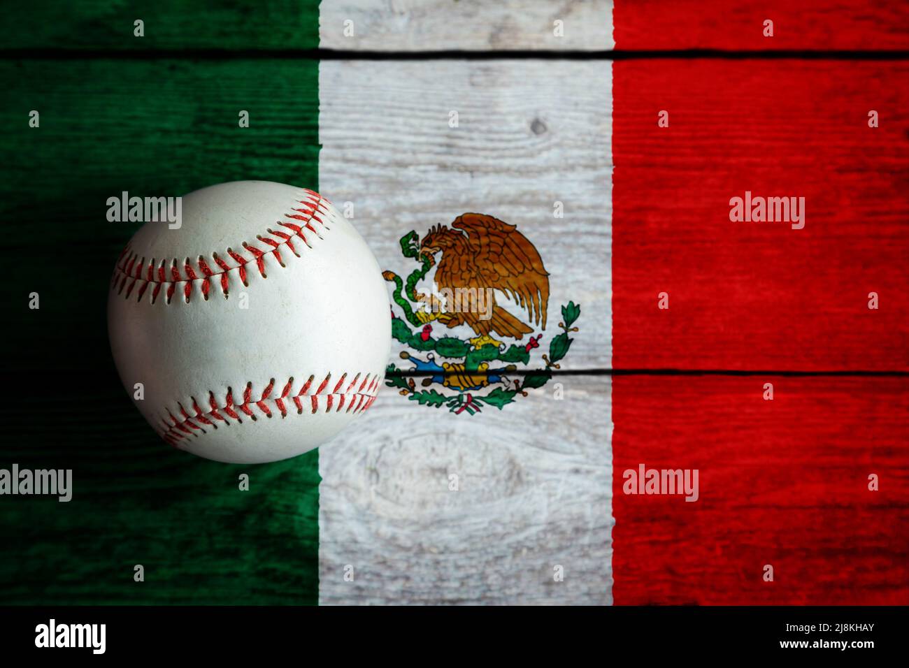 Leder-Baseballspiel auf rustikalem Holzhintergrund mit mexikanischer Flagge mit Kopierraum bemalt. Mexiko ist eine der führenden Baseballnationen der Welt. Stockfoto
