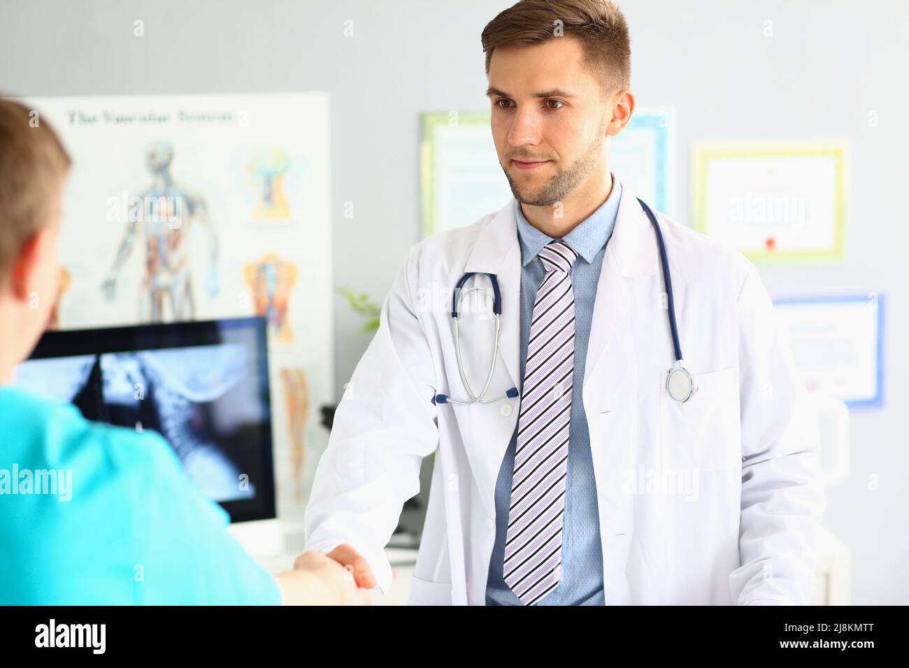 Facharzt begrüßt Kollegen, freundliche Handshake-Geste, intelligenter Arzt trägt medizinische Uniform Stockfoto