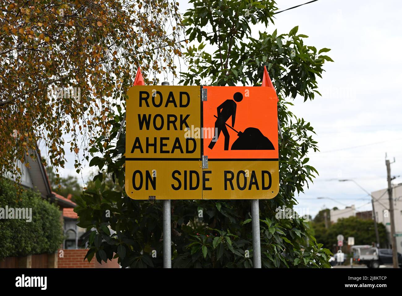 Gelbe Straßenarbeiten vor dem Straßenschild, mit orangefarbenem Quadrat mit einer schwarzen Ikone eines Mannes, der in einer Vorstadtstraße grabt Stockfoto