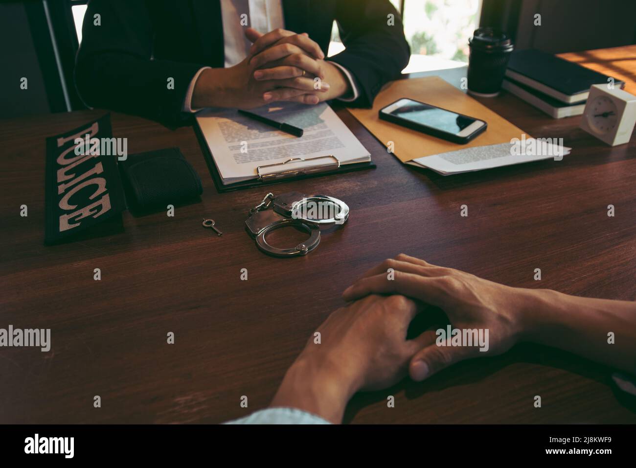 Angespannte Situation im Untersuchungsraum, in dem Polizisten und Angeklagte sprechen. Stockfoto