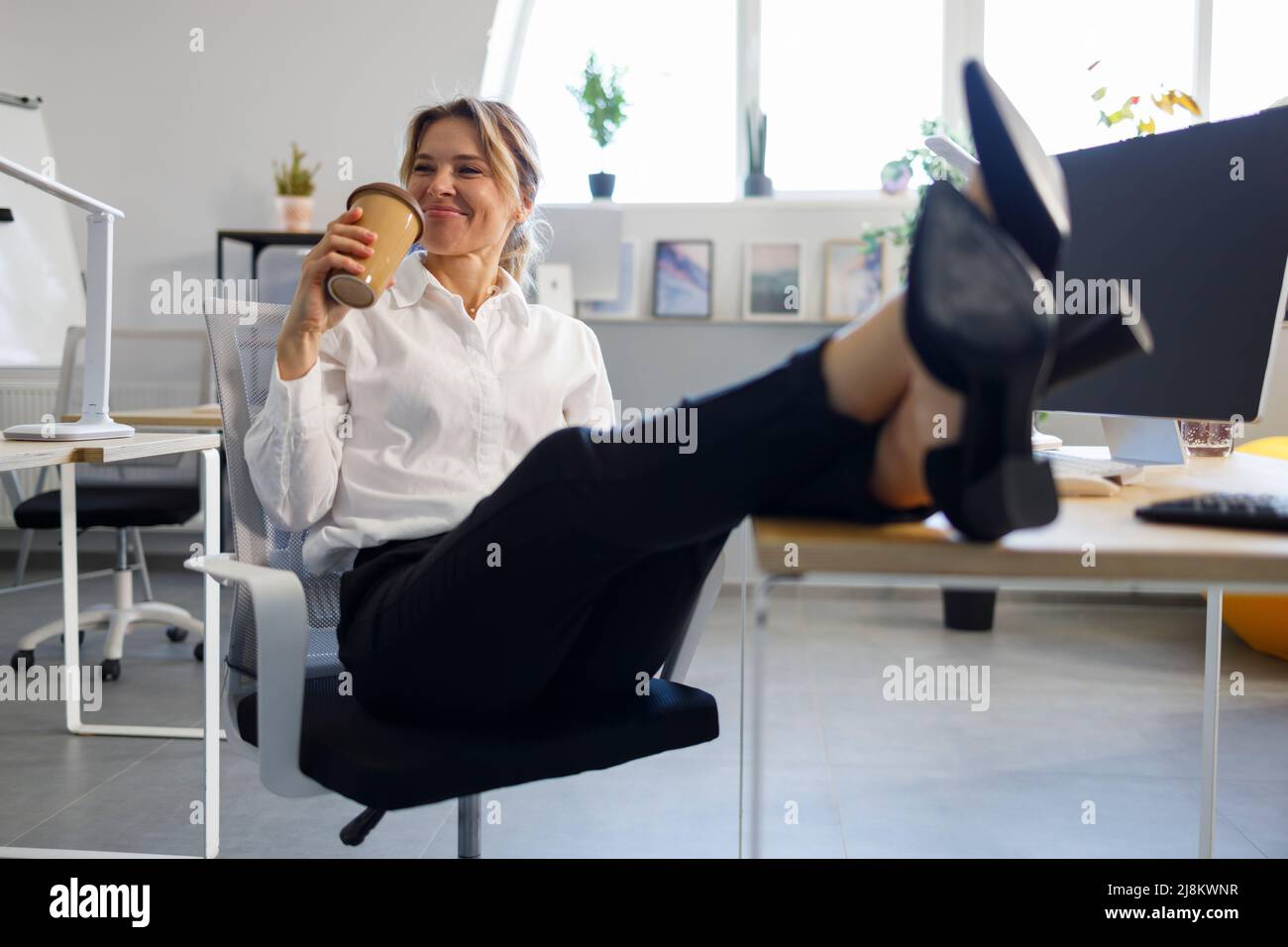 Bürofrau, die sich während der Kaffeepause entspannt Stockfoto