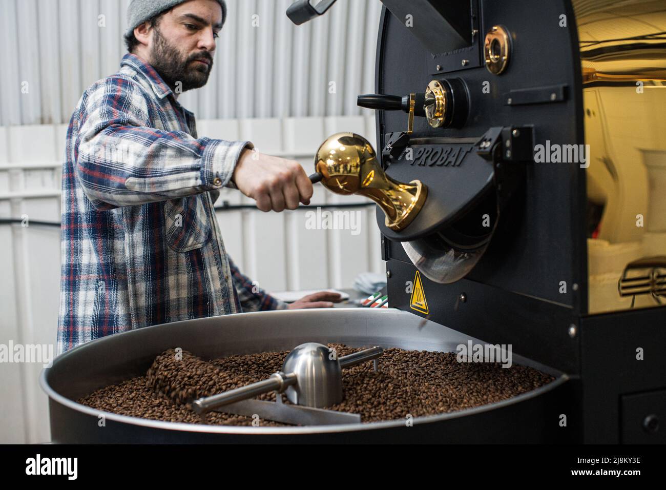 Ein kaffeeröster Kontrollen Kaffee Bohnen beim Rösten Stockfoto