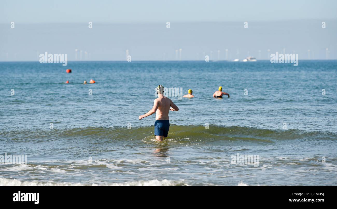 Brighton UK 17. May 2022 - Schwimmer genießen ein Bad am frühen Morgen in der Sonne von Brighton, da heute die Prognosen zufolge die heißesten des Jahres sein werden, da die Temperaturen in einigen Teilen Großbritanniens voraussichtlich 26 Grad erreichen werden: Credit Simon Dack / Alamy Live News Stockfoto