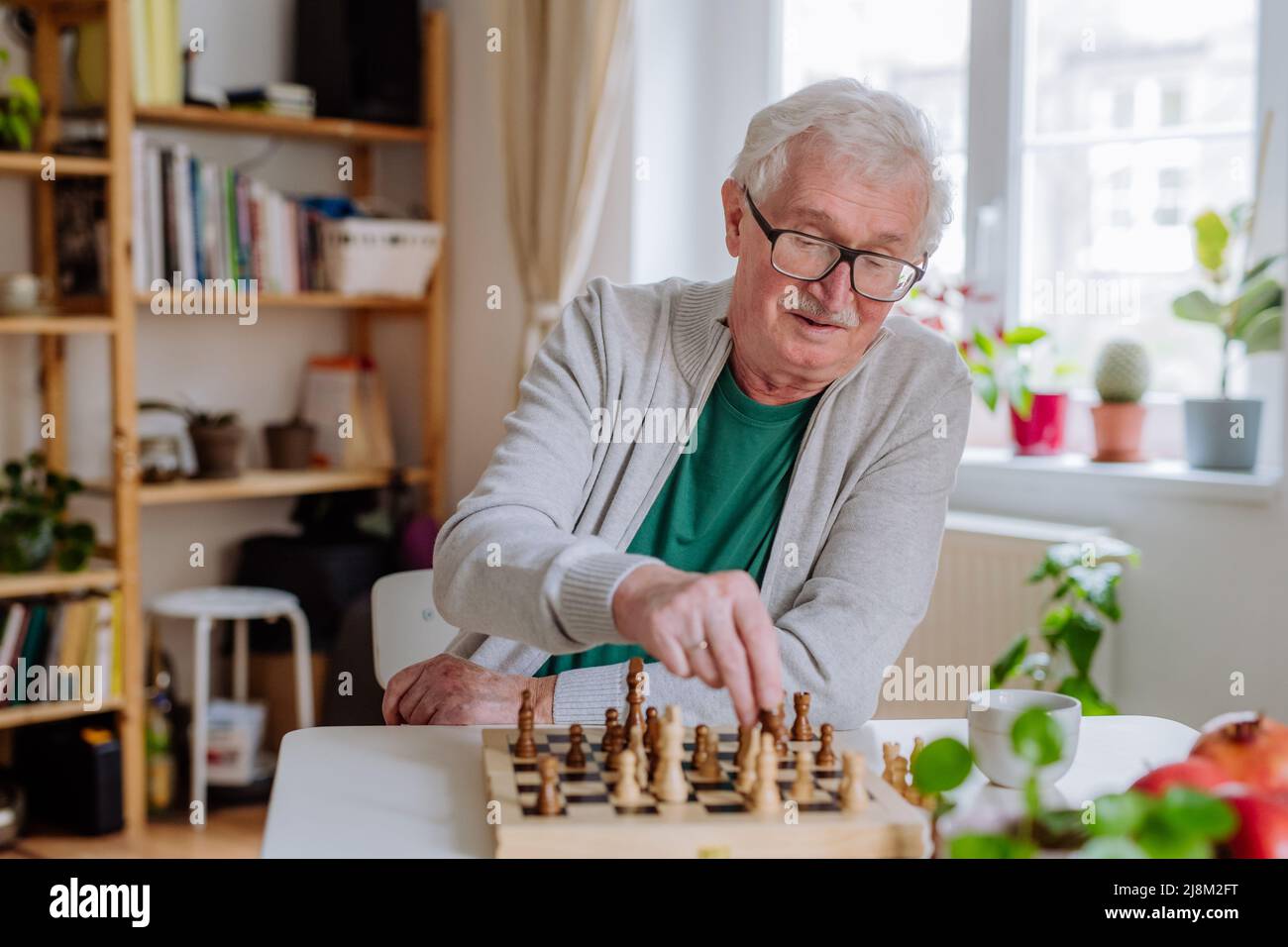 Älterer Mann, der zu Hause ein Schach spielt. Stockfoto