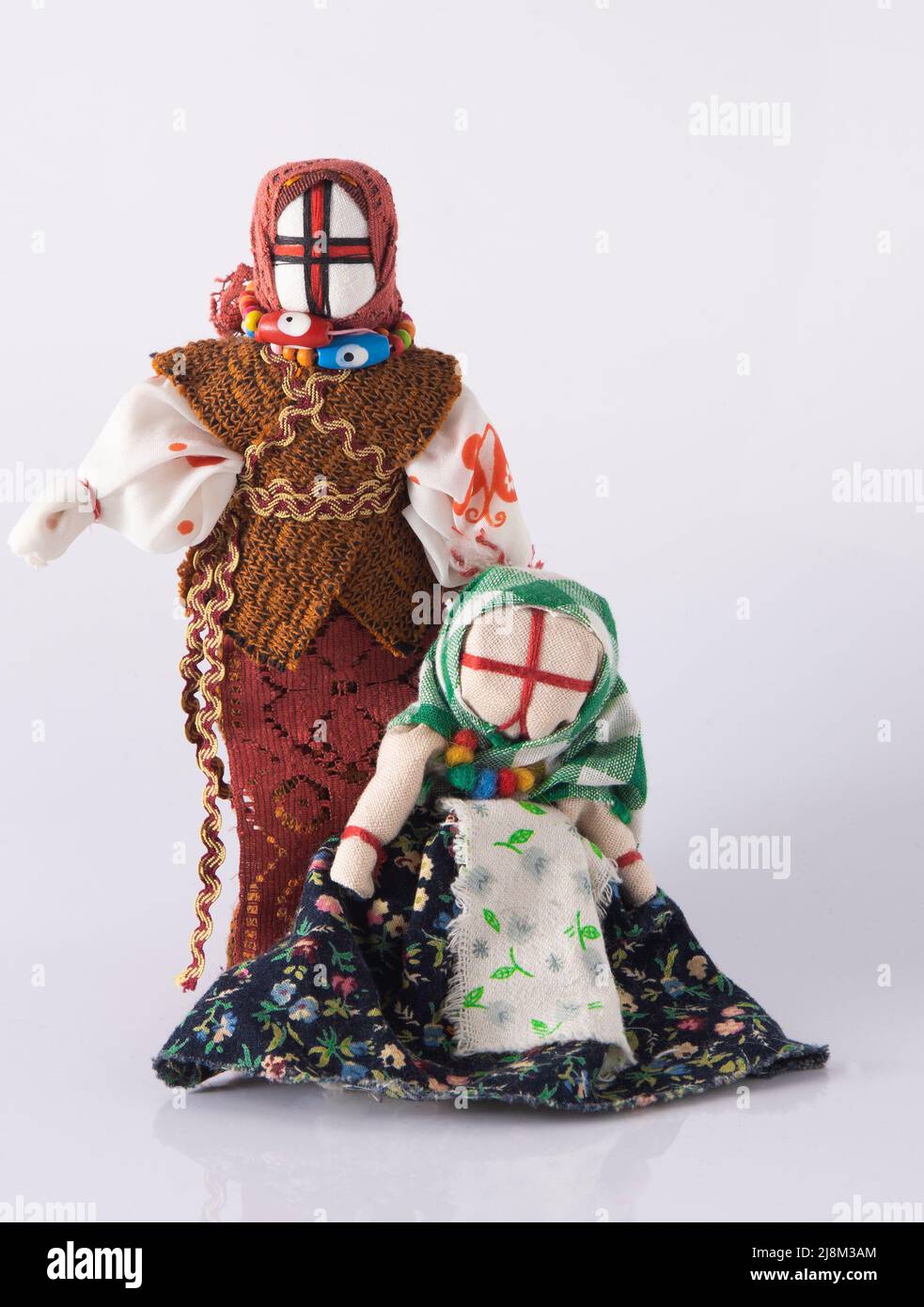 Lyalka motanka handgefertigt. Ukrainisches Puppenamulett, Schlammflecken und Fäden werden ohne Nadel hergestellt. Symbol der Ukraine. Motanka Puppen auf weißem Hintergrund. Altes Spielzeug. Stockfoto