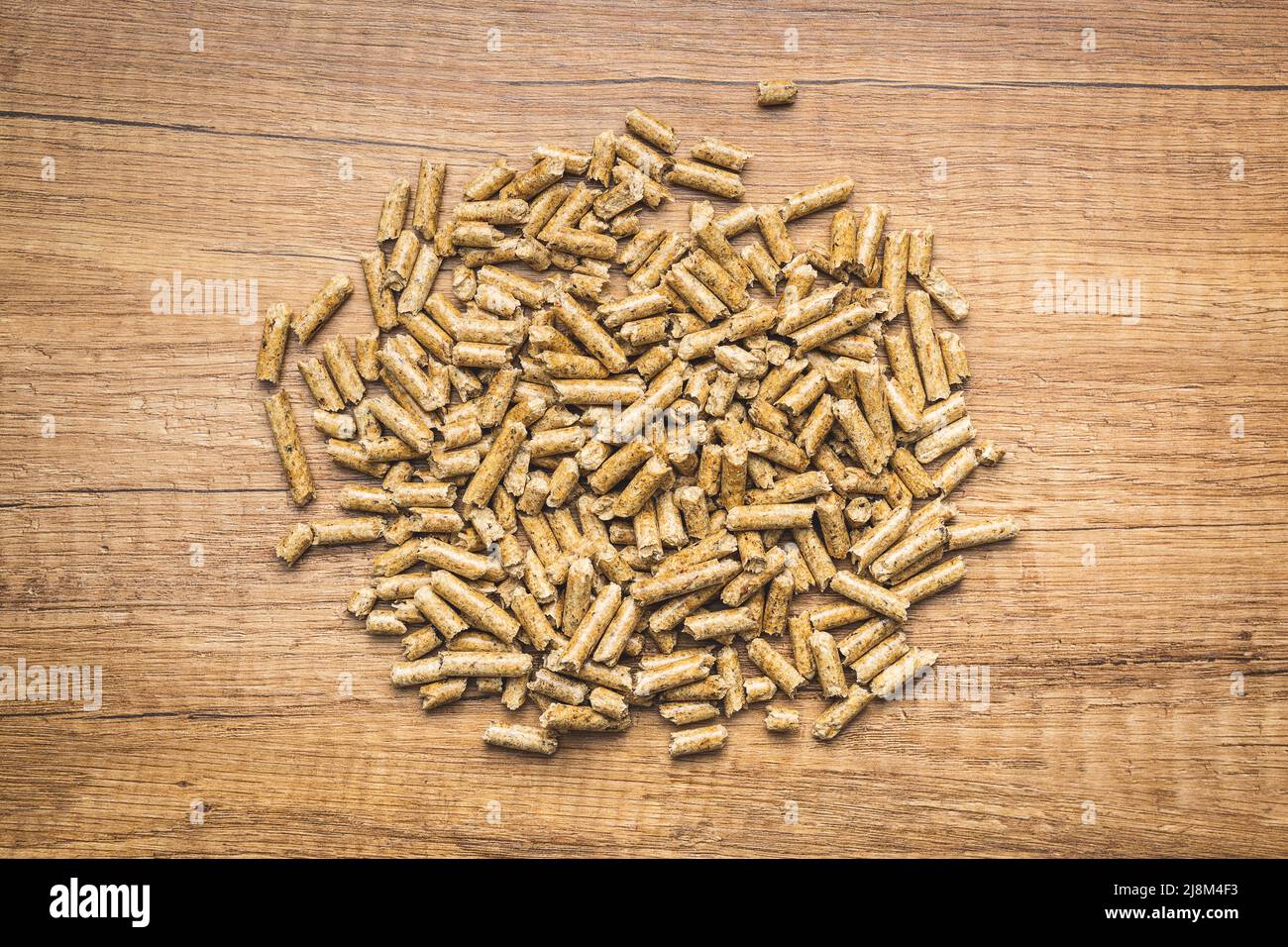 Holzpellets, Biokraftstoff auf einem Holztisch. Ökologischer Brennstoff aus Biomasse. Erneuerbare Energiequellen. Draufsicht. Stockfoto