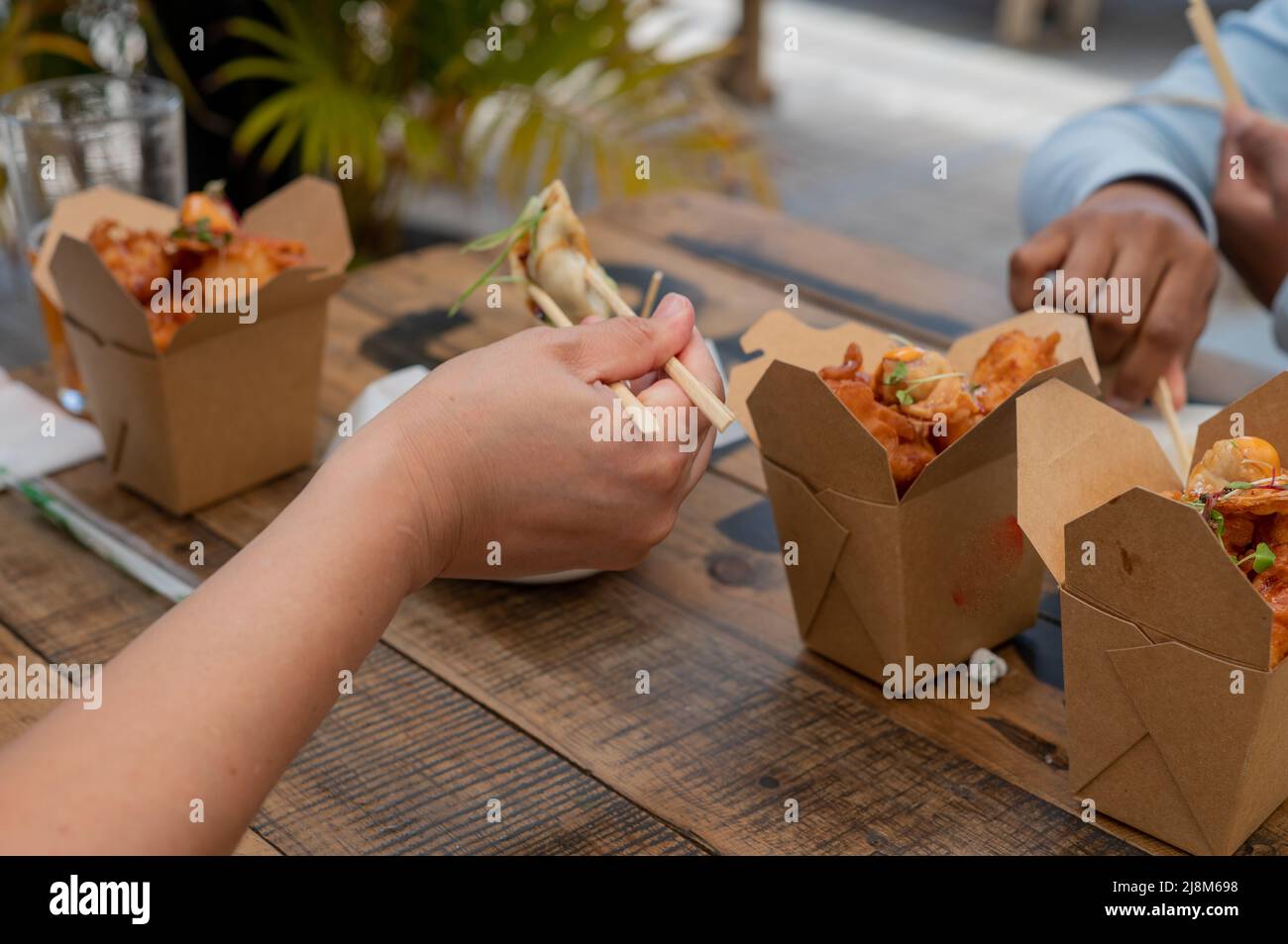 Menschen essen chinesisches Essen mit Stöcken Stockfoto