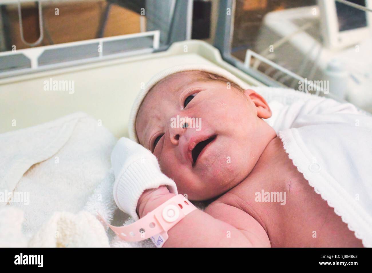 Neugeborenes Mädchen, das gerade im Krankenhaus auf der Entbindungsstation mit einem Plastikschild am Handgelenk geboren wurde Stockfoto