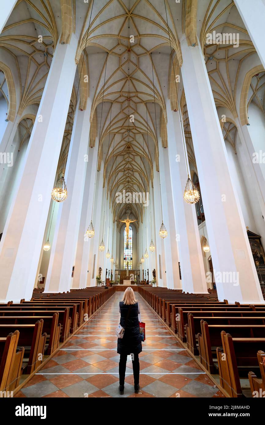 Deutschland Bayern München. Frauenkirche. Eine blonde, stehende Frau bewundert das Innere des Doms und verbringt Zeit in Stille und Kontemplation Stockfoto