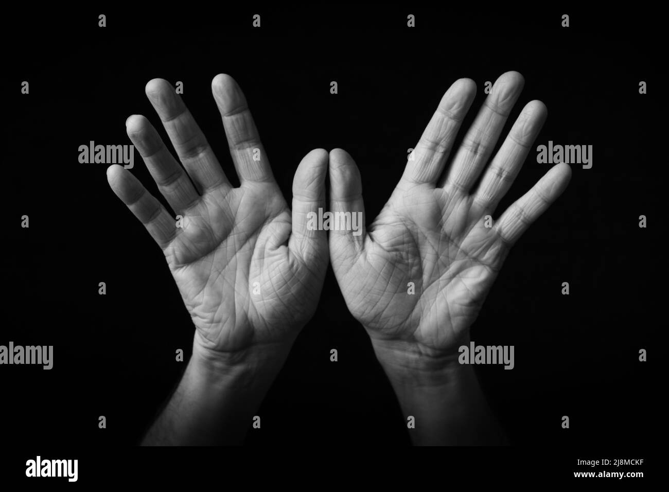 Dramatisches Schwarz-Weiß-Bild von Open Hands Emoji auf schwarzem Hintergrund isoliert Stockfoto