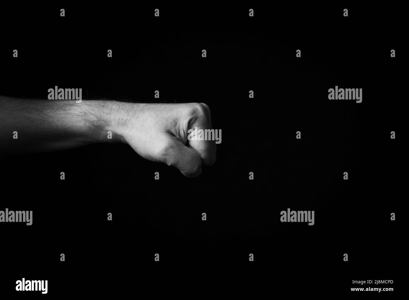 Dramatisches Schwarz-Weiß-Bild des rechts gerichteten Fist-Emojis auf schwarzem Hintergrund isoliert Stockfoto