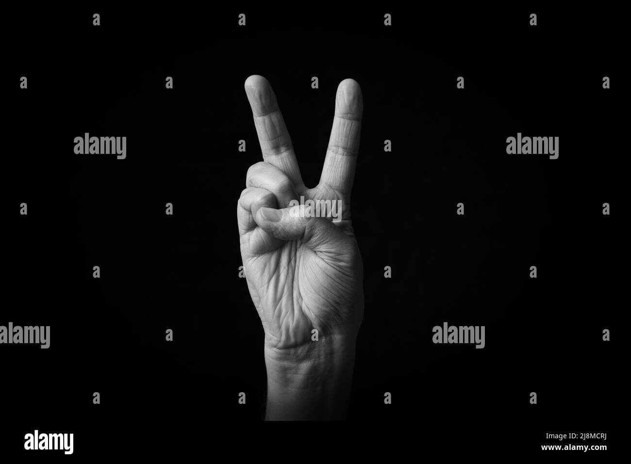 Dramatisches Schwarz-Weiß-Bild der britischen Victory Hand Emoji isoliert auf schwarzem Hintergrund Stockfoto