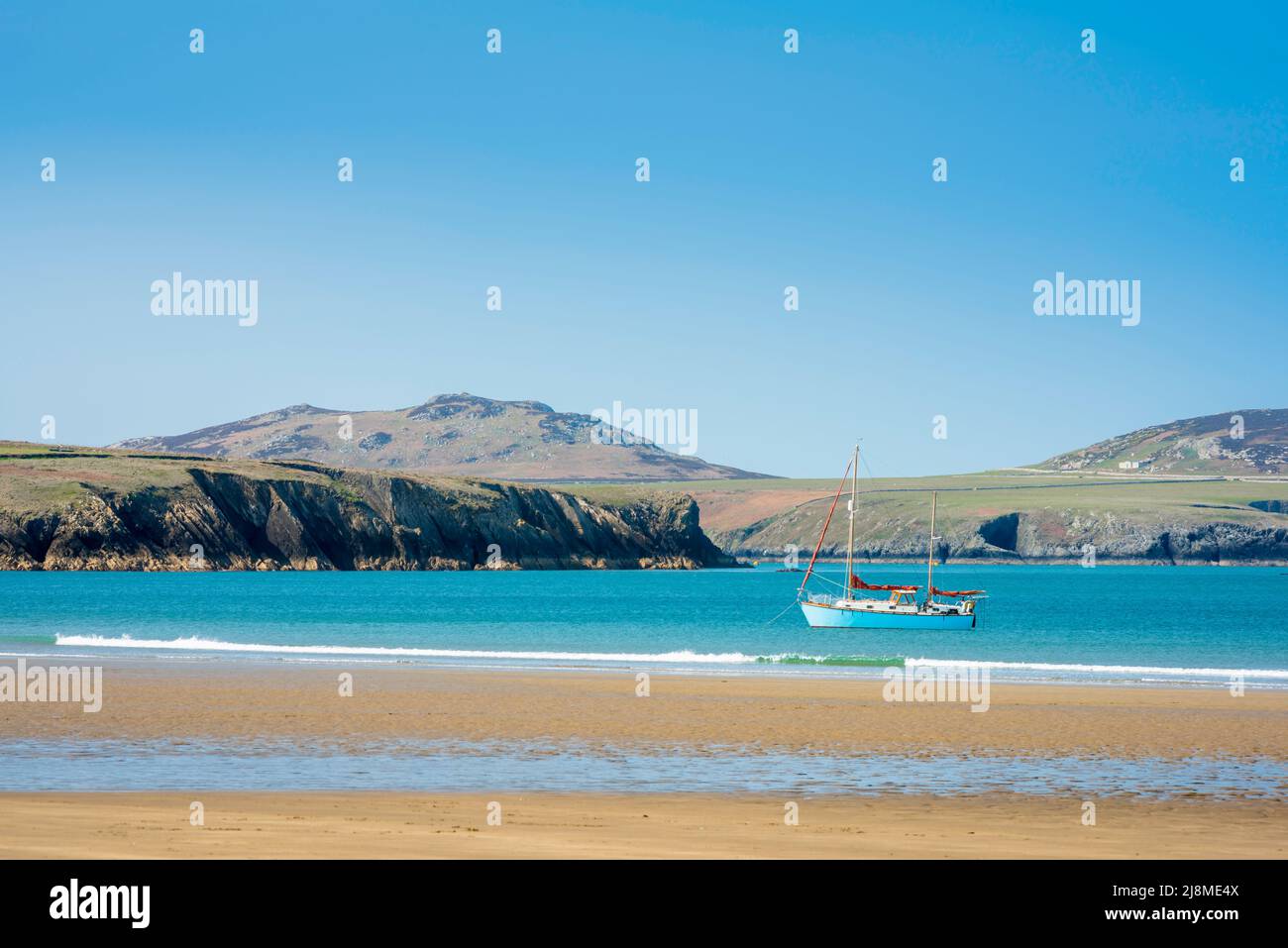 Strand an der Küste von Wales, Blick an einem Sommermorgen auf eine Yacht vor dem Strand in Whitesands Bay an der Küste von Pembrokeshire, Wales, Großbritannien Stockfoto