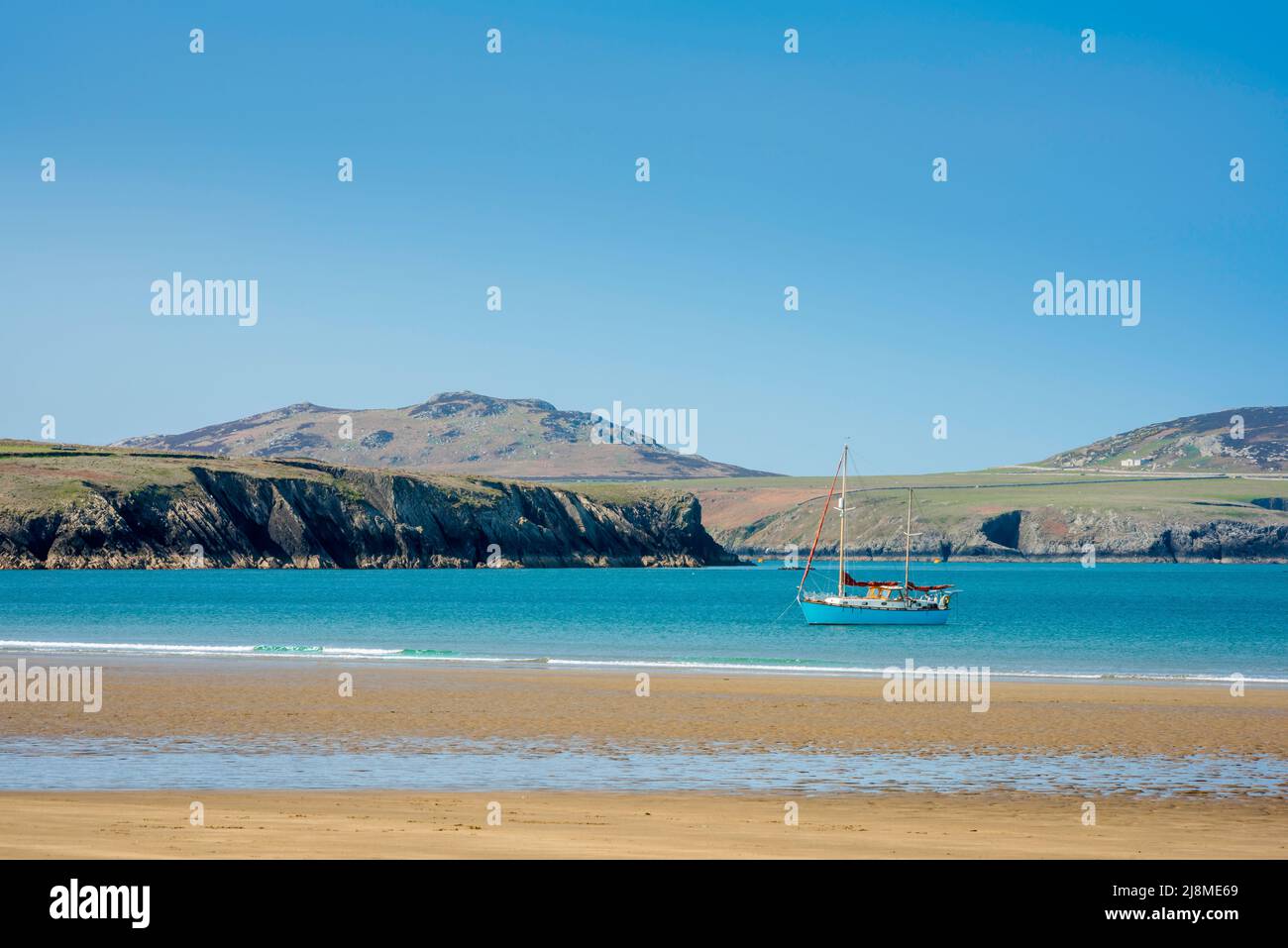 Lifestyle-Reisen, Blick an einem Sommertag auf eine Yacht, die in der Nähe eines einsamen europäischen Strandes festgemacht ist. Stockfoto