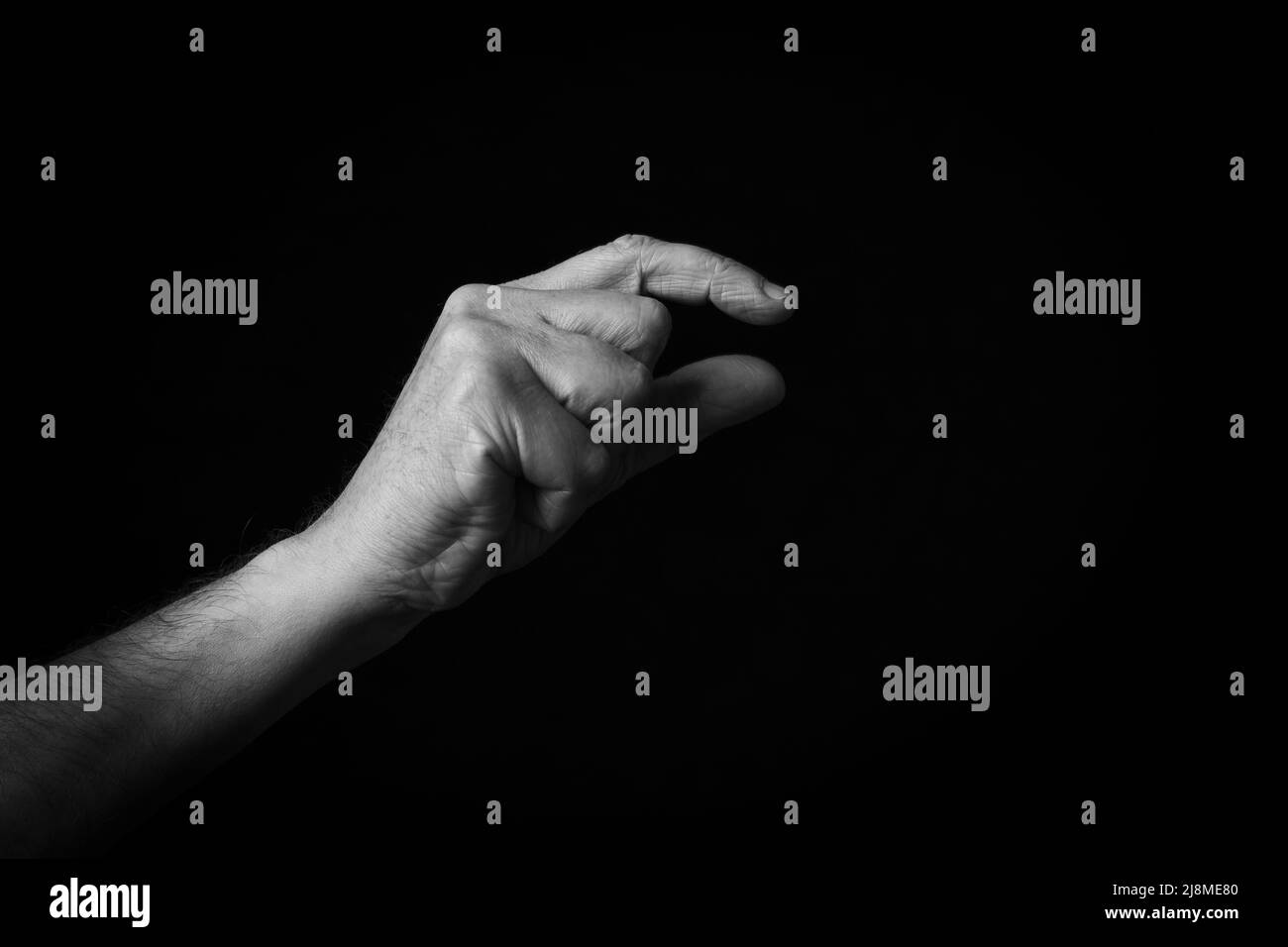 Dramatisches Schwarz-Weiß-Bild von zusammenkneifenden Hand-Emoji auf schwarzem Hintergrund isoliert Stockfoto