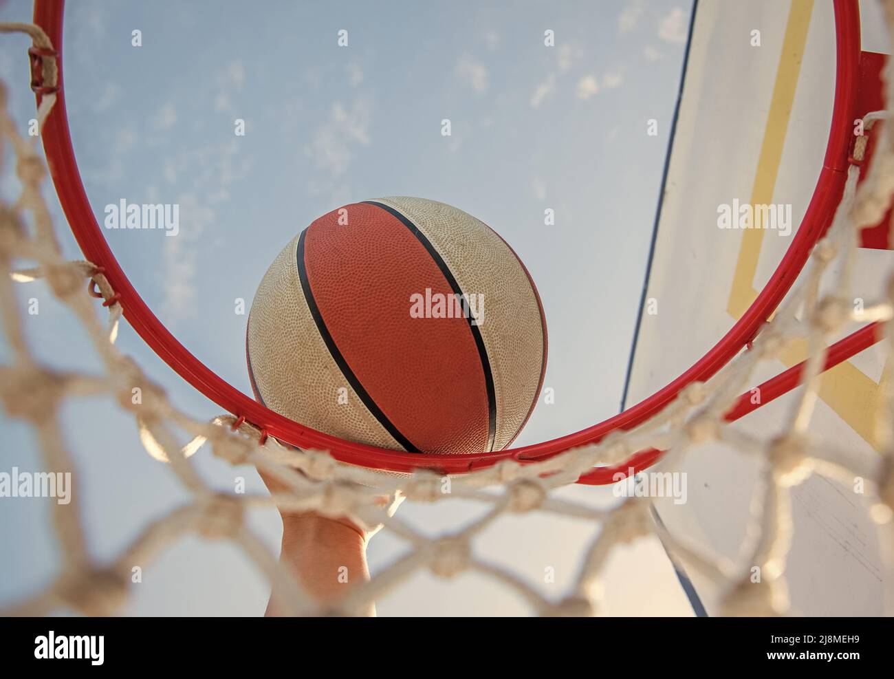 Dunking Basketball Ball durch Netzring mit der Hand, Basketball Stockfoto