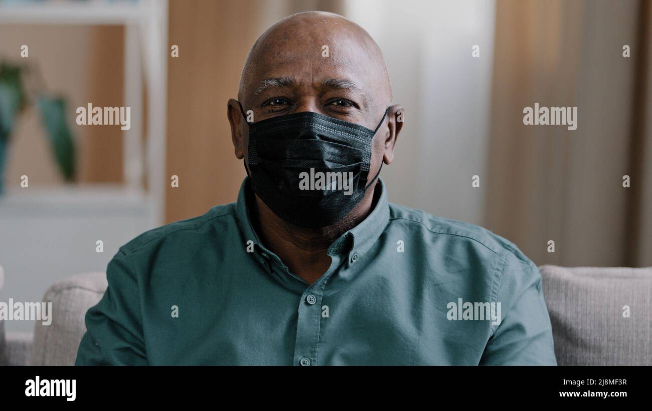 Portrait alt einsam african dominican reifen Mann 60s Großvater reifen älteren männlichen traurig nachdenklichen Patienten in schwarzer medizinischer Maske zu Hause suchen drinnen Stockfoto