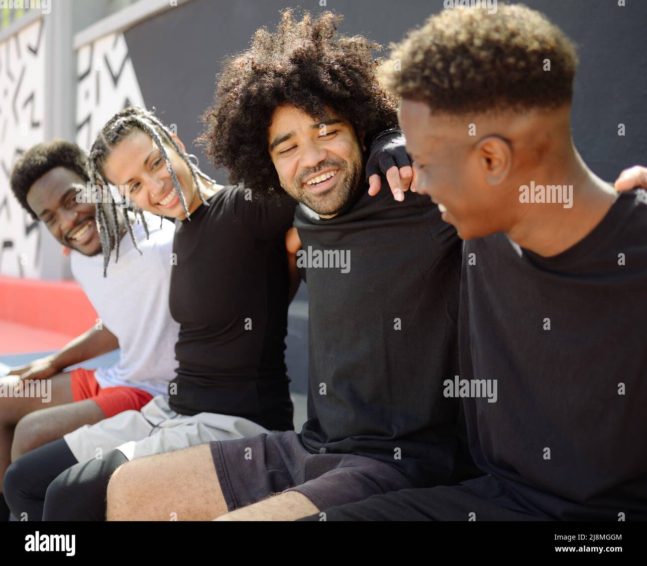 Fröhliches schwarzes Basketballteam, das sich auf dem Platz umarmt Stockfoto