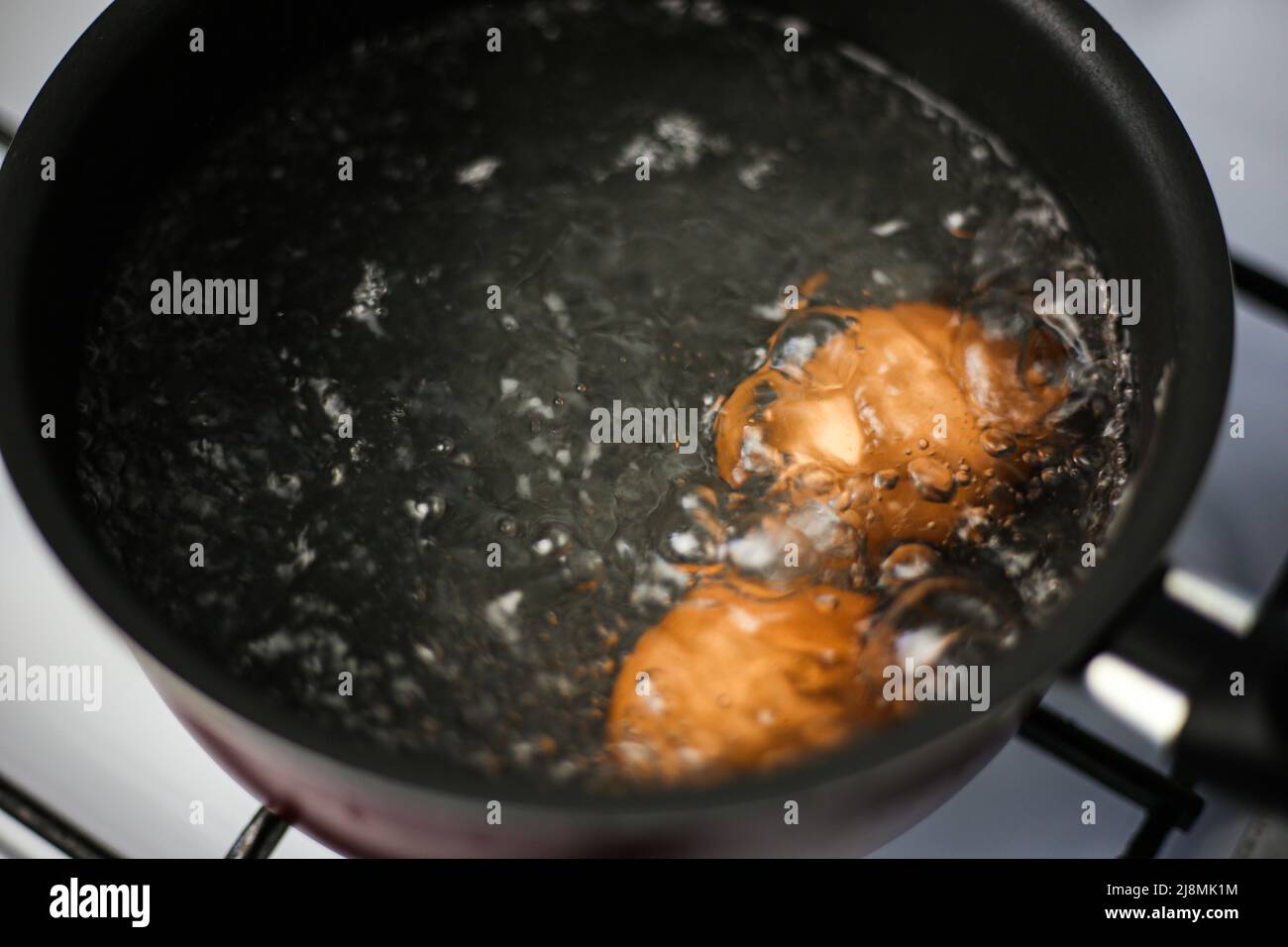 Zwei braune Eier in einem Topf mit kochendem Wasser Stockfoto