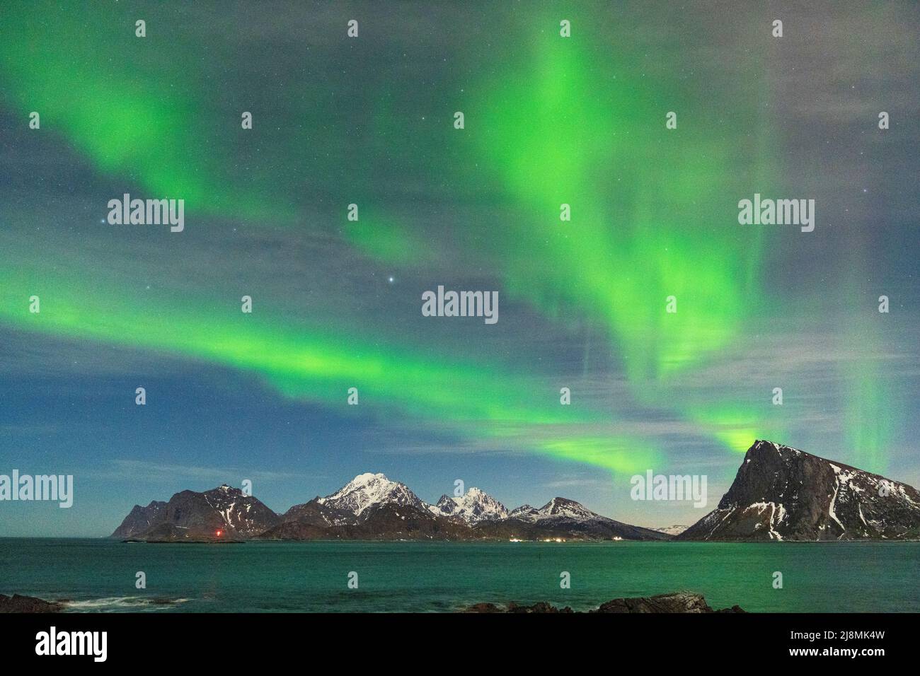 Grüne Lichter von Aurora Borealis über majestätischen Bergen und Meer, Myrland, Leknes, Vestvavoy, Lofoten-Inseln, Norwegen Stockfoto