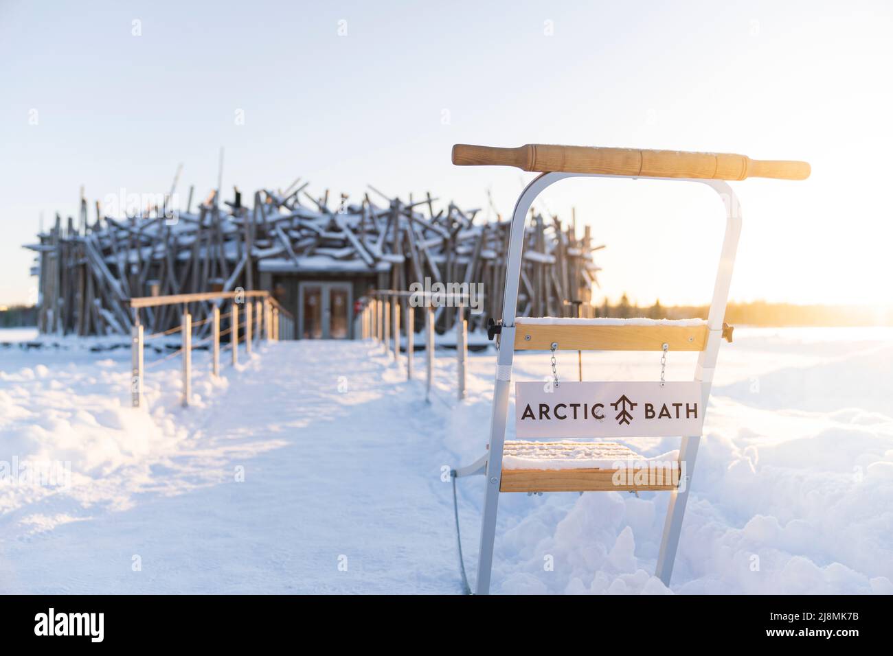Kreisförmiges Hauptgebäude des Arctic Bath Hotel, das durch einen Gehweg am gefrorenen Fluss Lule, Harads, Lappland, Schweden, mit dem Ufer verbunden ist Stockfoto