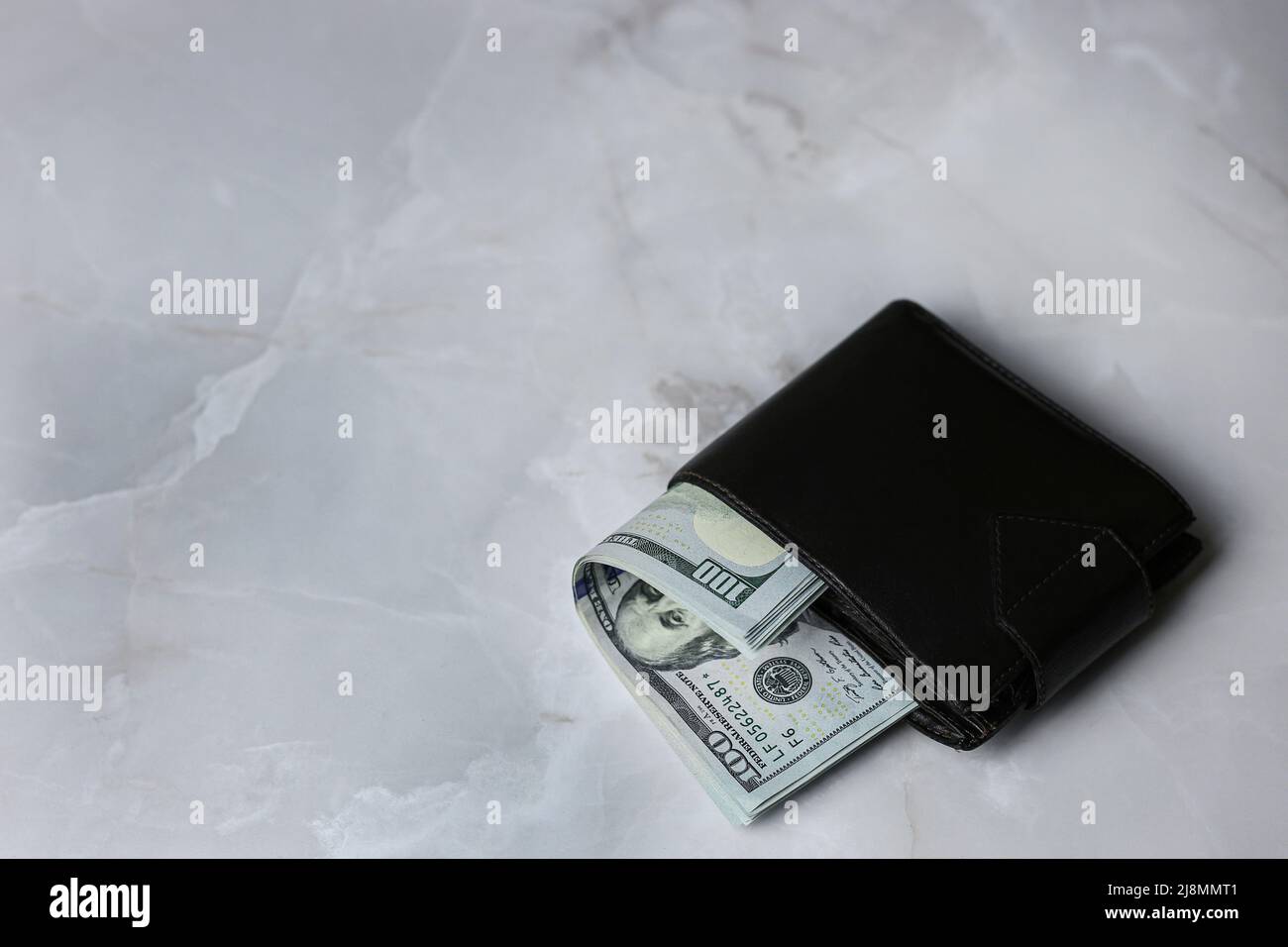 Ein Stapel von 100 US-Dollar-Banknoten, gefaltet in einer geschlossenen Brieftasche auf einem hellen Hintergrund Stockfoto Ein Stapel von 100 US-Dollar-Banknoten, gefaltet in einer geschlossenen Brieftasche auf einem hellen Hintergrund Stockfoto
