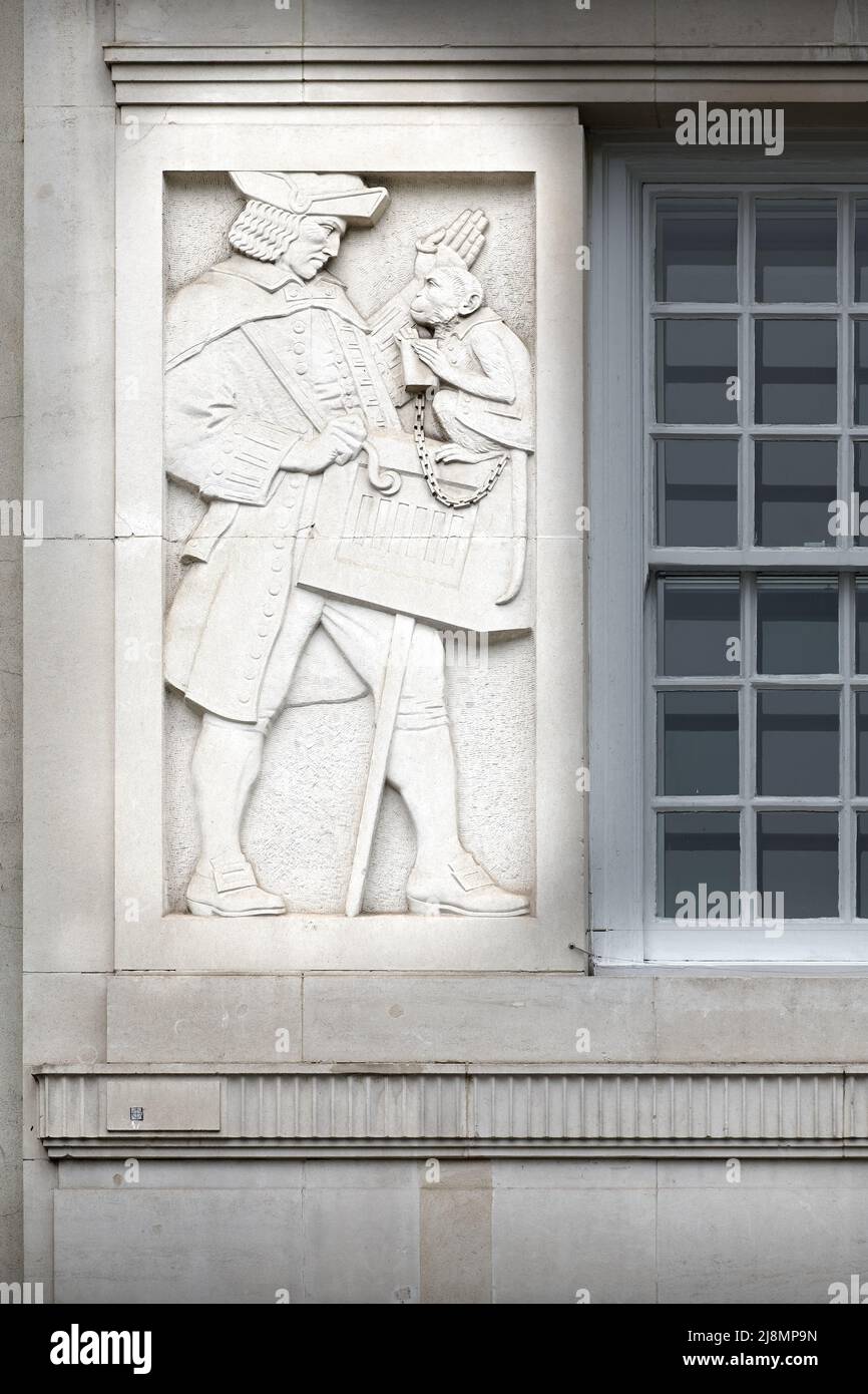 Kostüme aus dem 18.. Jahrhundert n. Chr. in einer Skulptur auf einem Gebäude aus dem Jahr 1933, The Coach Health Club, St. James's Square, London, England. Stockfoto