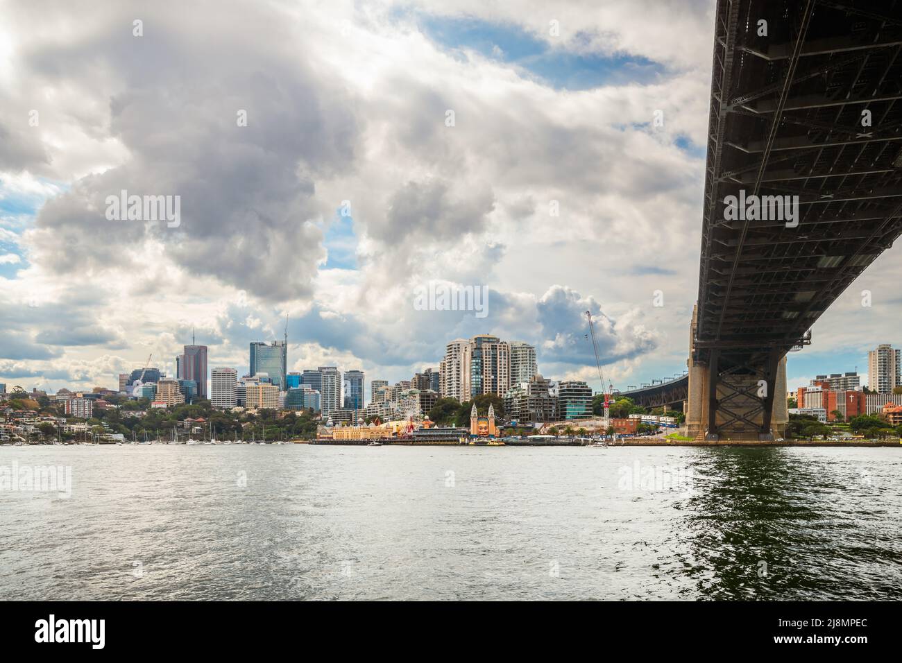 Sydney, Australien - 16. April 2022: North Sydney mit Luna Park an einem Tag entlang der Sydney Harbour Bridge vom gegenüberliegenden Ufer aus gesehen Stockfoto