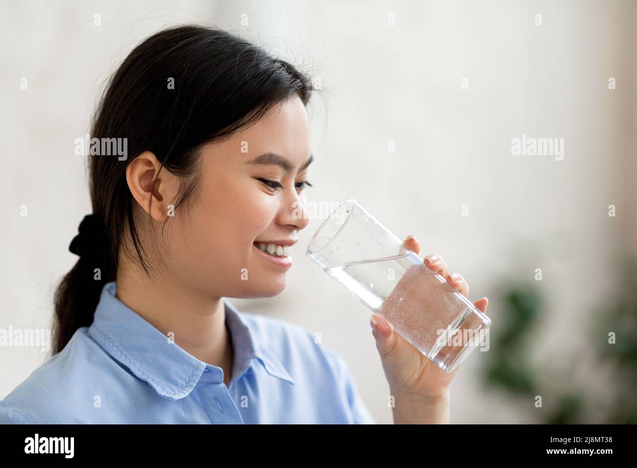 Seitenansicht der koreanischen Frau, die Wasser trinkt Stockfoto