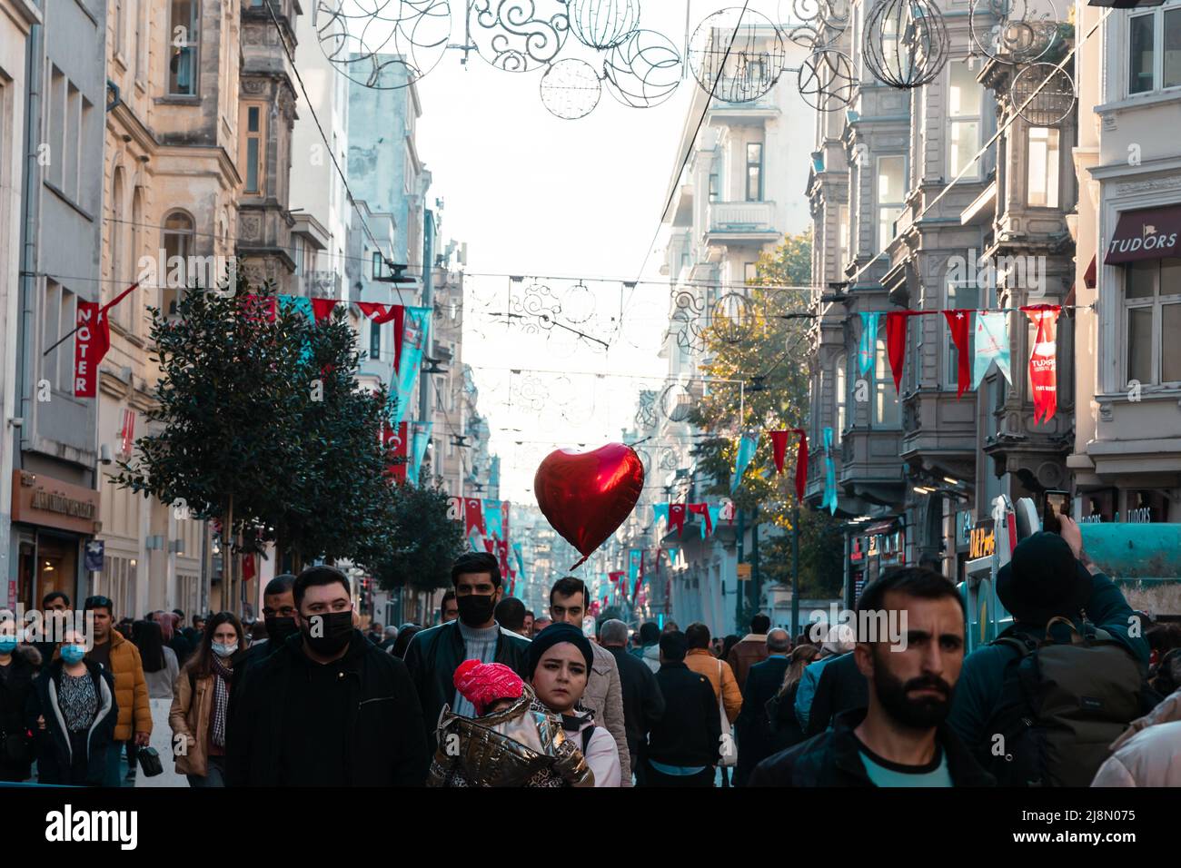 Menschen in der Istiklal Avenue oder Istiklal Caddesi mit einem herzförmigen Ballon. Istanbul Türkei - 11.13.2021 Stockfoto
