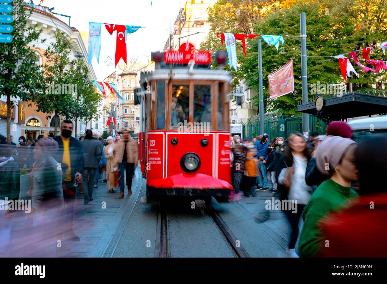 Nostalgische Straßenbahn in der Istiklal Avenue. Bewegungsunschärfen auf der Straßenbahn und den Menschen. Istanbul Türkei - 11.13.2021 Stockfoto