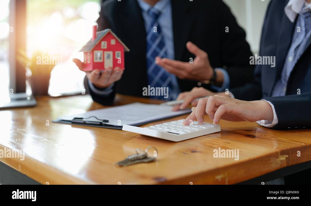 Immobilienmakler sprach über die Bedingungen des Hauskaufvertrags und bat den Kunden, die Dokumente zu unterzeichnen, um den Vertrag legal zu machen Stockfoto