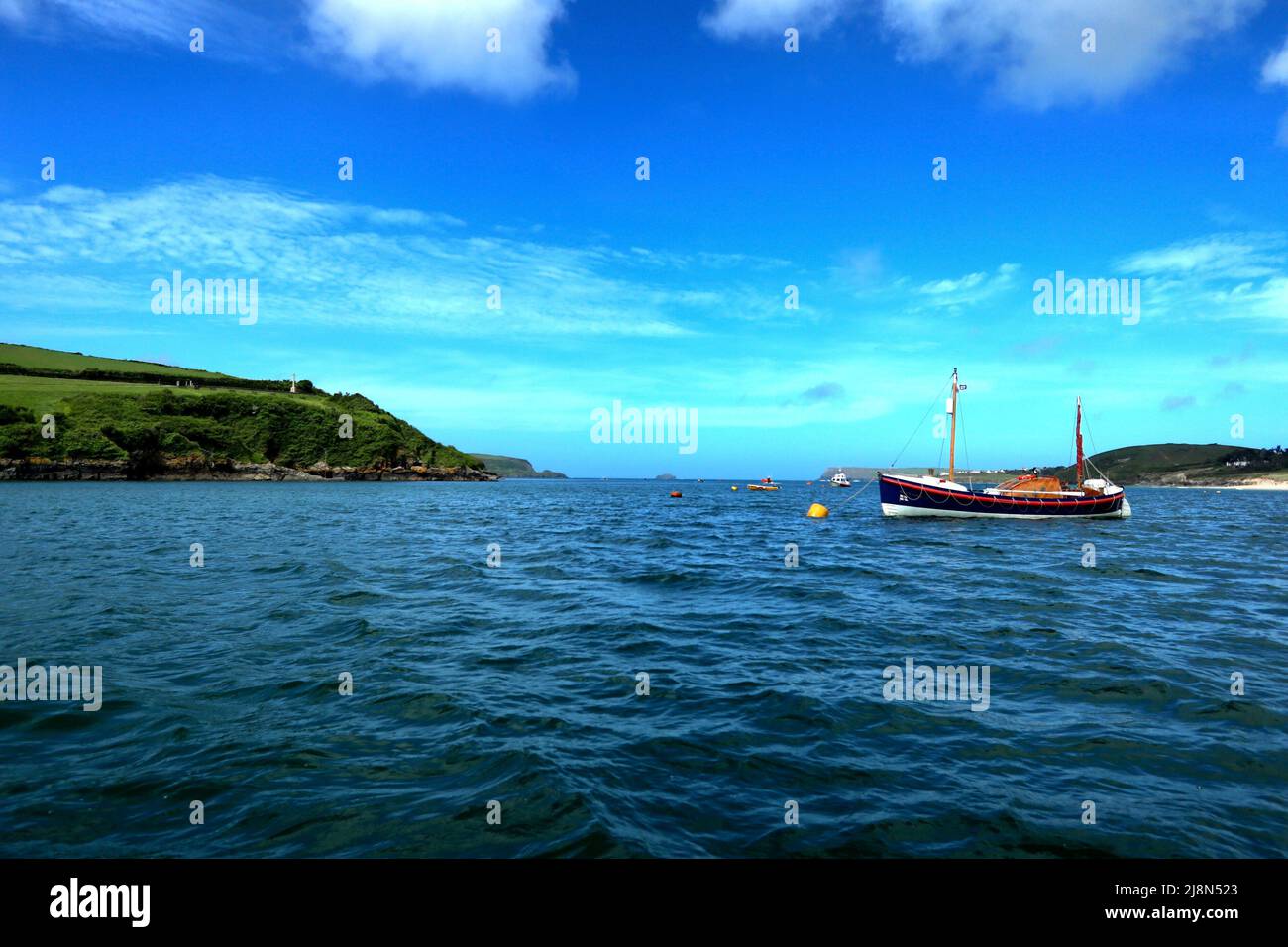 Überqueren Sie die Kamelmündung mit der Black Tor Fähre, zwischen Padstow und Rock, mit einem alten Rettungsboot an einem Liegeplatz. Stockfoto