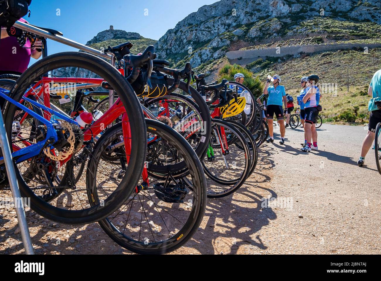 Radfahrer, die sich während des Wettkampfes durch geparkte Fahrräder gegen den Berg ausruhen Stockfoto