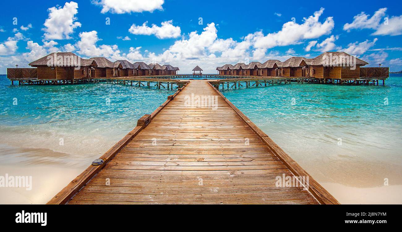 Der Steg führt vom Strand zu luxuriösen Überwasser-Bungalows, dem Süd-Male-Atoll der Malediven, dem Indischen Ozean und Asien Stockfoto