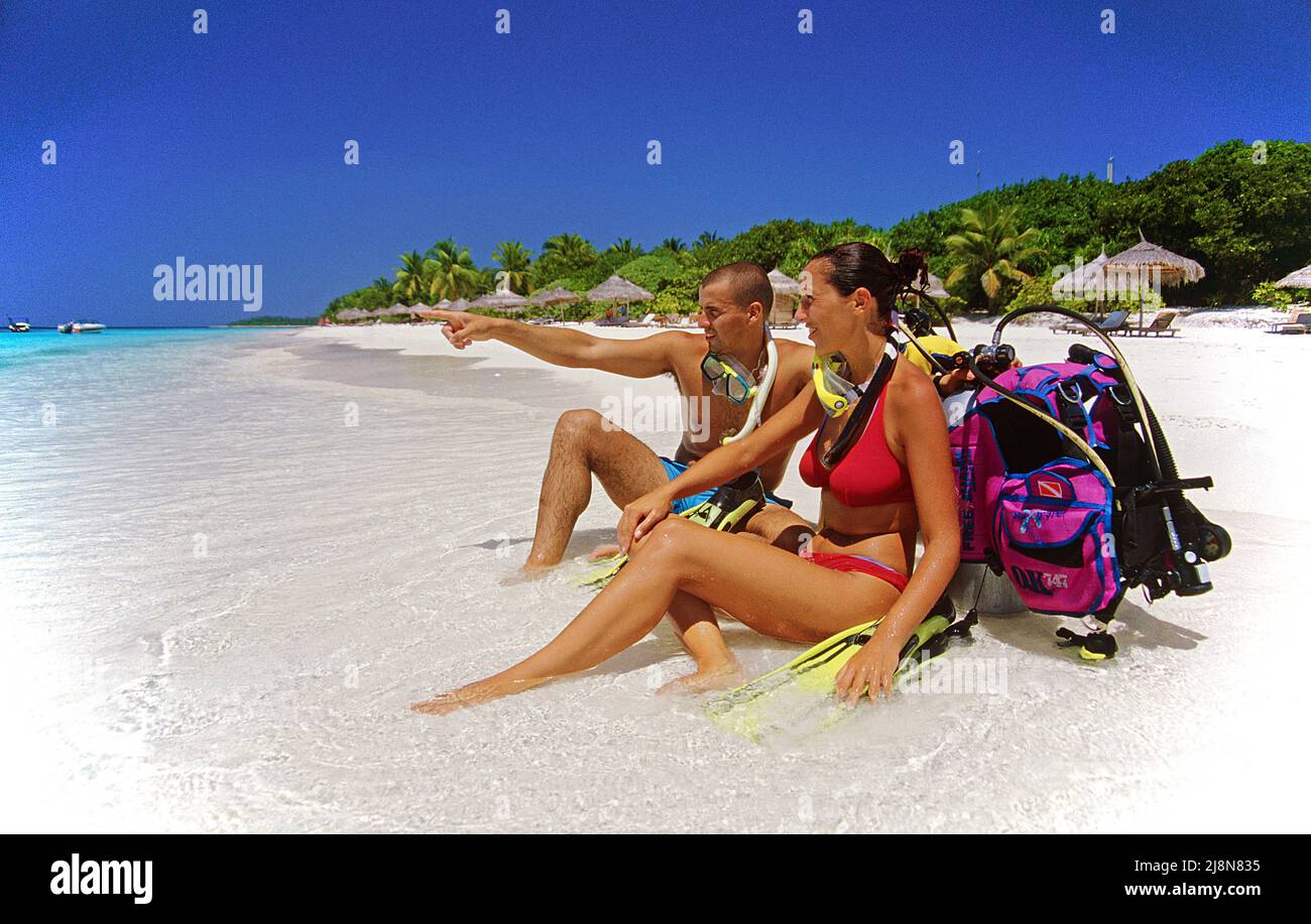 Paar mit Tauchausrüstung am Strand der maledivischen Insel Reethi Beach, Baa-Atoll, Malediven, Indischer Ozean, Asien Stockfoto