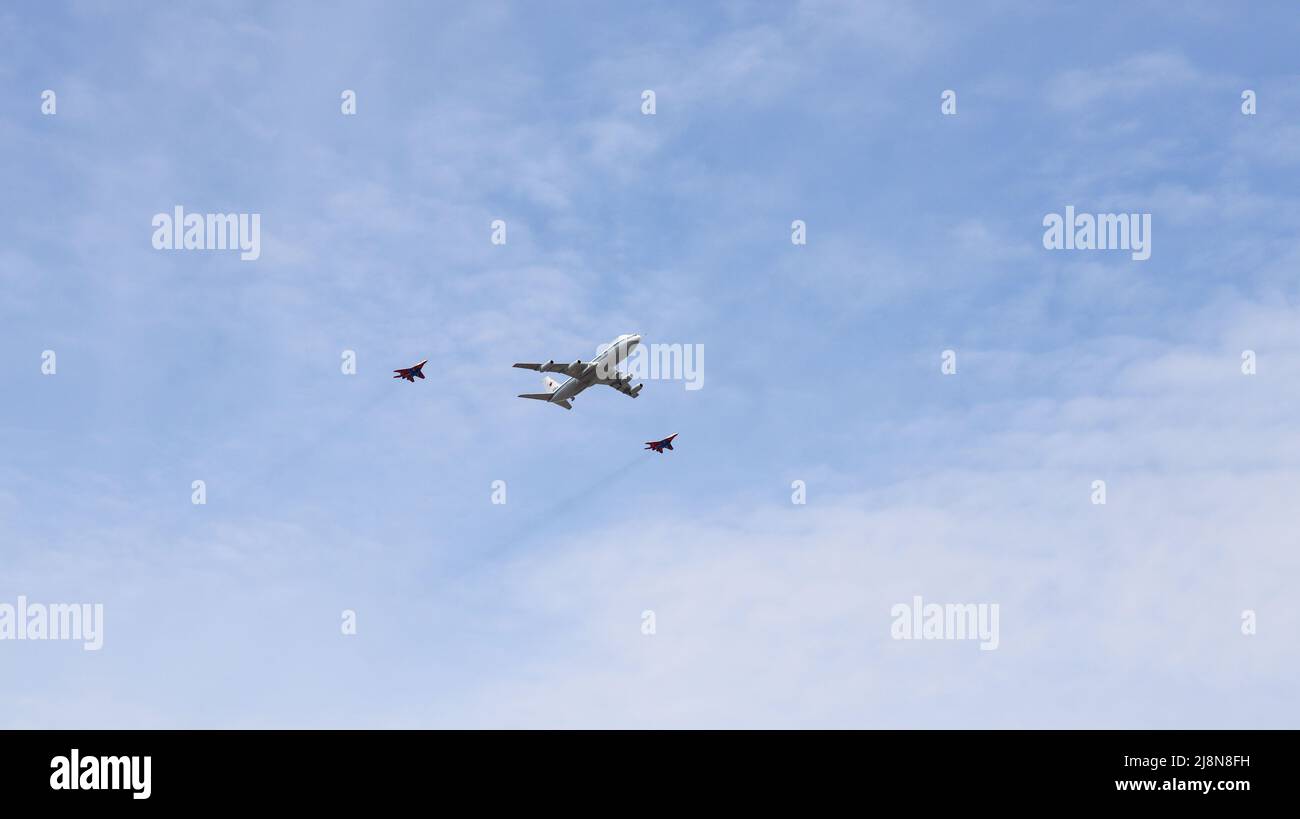 Moskau, Russland, 2022. Mai: DAS LUFTKONTROLLZENTRUM IL-80, auch Doomsday-Flugzeug genannt, wird von zwei Mig-29-Kämpfern begleitet. An Th Stockfoto
