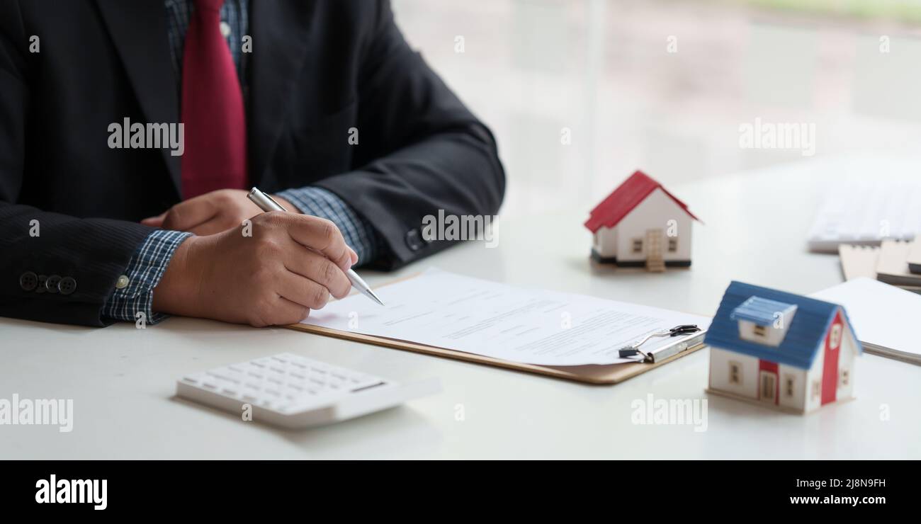 Nahaufnahme des Geschäftsmannes zeigen und unterzeichnen Vereinbarung für den Kauf von Haus. Konzept des Bankleiters. Stockfoto
