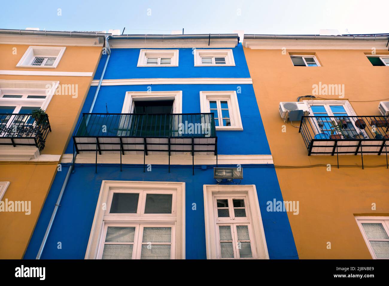 Low Angle View of Colorful Building Exteriors with paned Windows and small balconies, Valencia, Spain Stockfoto