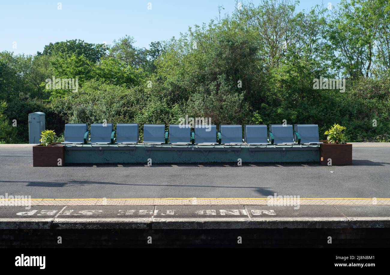 Leere Sitzreihe auf einer Bahnhofsplattform. Gibt ein Gefühl von Ruhe, Leere, vergessen oder ungenutzt. Außerhalb der Spitzenzeiten oder im Streik? Stockfoto