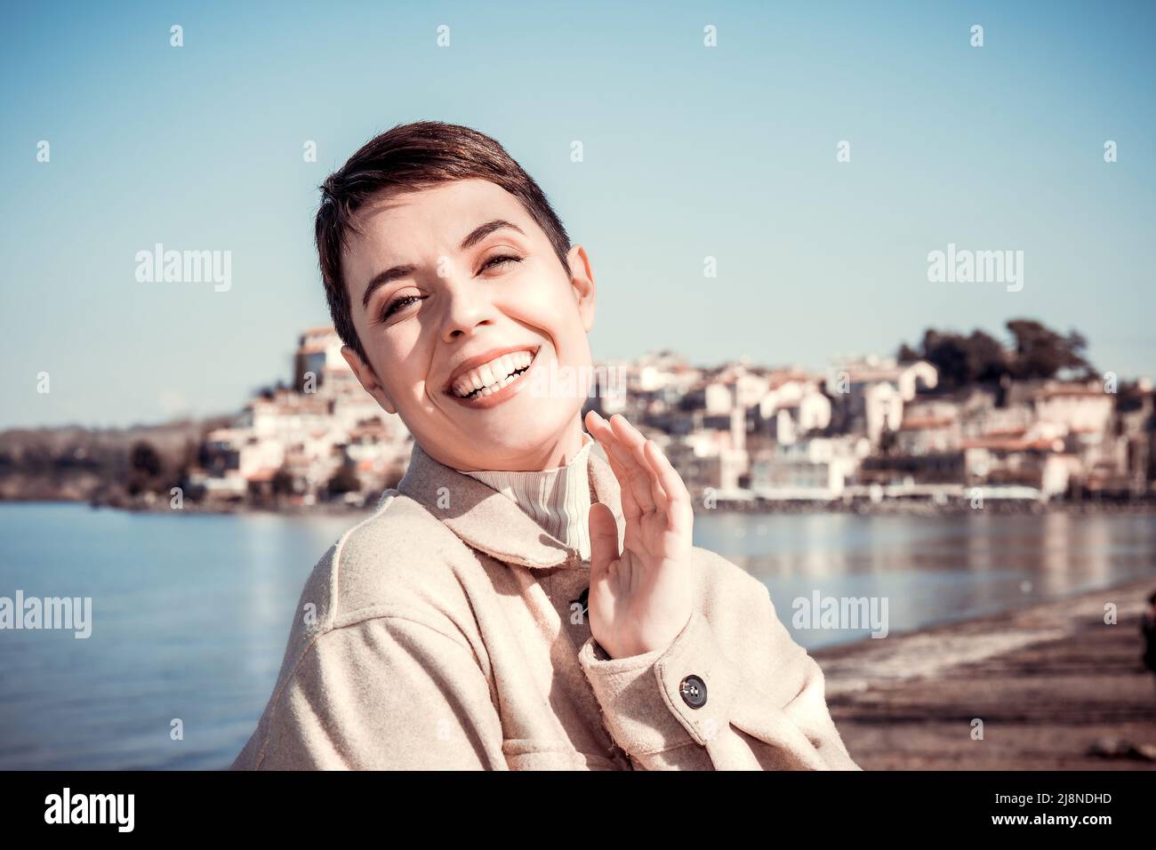 Schöne Frau, die nach Anguillara Sabazia reist, einem schönen italienischen Dorf. Frau mit kurzen Haaren lächelt und schaut in die Kamera. Speicherplatz kopieren Stockfoto