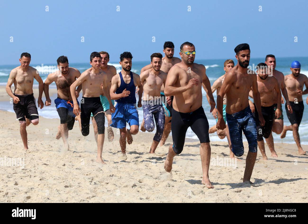 Gaza, Palästina. 17.. Mai 2022. Palästinensische Teilnehmer führen Aufwärmübungen durch, bevor sie den Schwimmkurs für Rettungsschwimmer am Strand von Gaza-Stadt besuchen. Die Stadtverwaltung Gaza organisierte einen Schwimmbadlifeguard-Kurs, um palästinensische Schwimmschwimmer auszuwählen, die im Sommer im Rahmen des Schwimmlifeguard-Programms am Strand der Stadt gemietet werden sollten. Vor der Auswahl der Teilnehmer wurde ein schwierigtes und mühsames Training durchgeführt. Kredit: SOPA Images Limited/Alamy Live Nachrichten Stockfoto