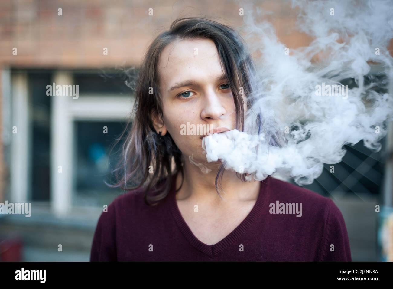 Porträt eines jungen Mannes im Zigarettenrauch Stockfoto