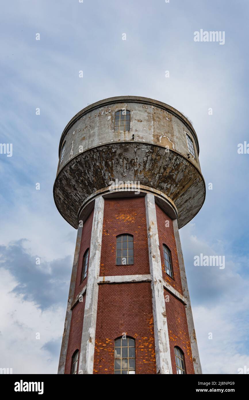 Hoher roter Ziegelturm als Teil des alten Fabrikkomplexes Stockfoto