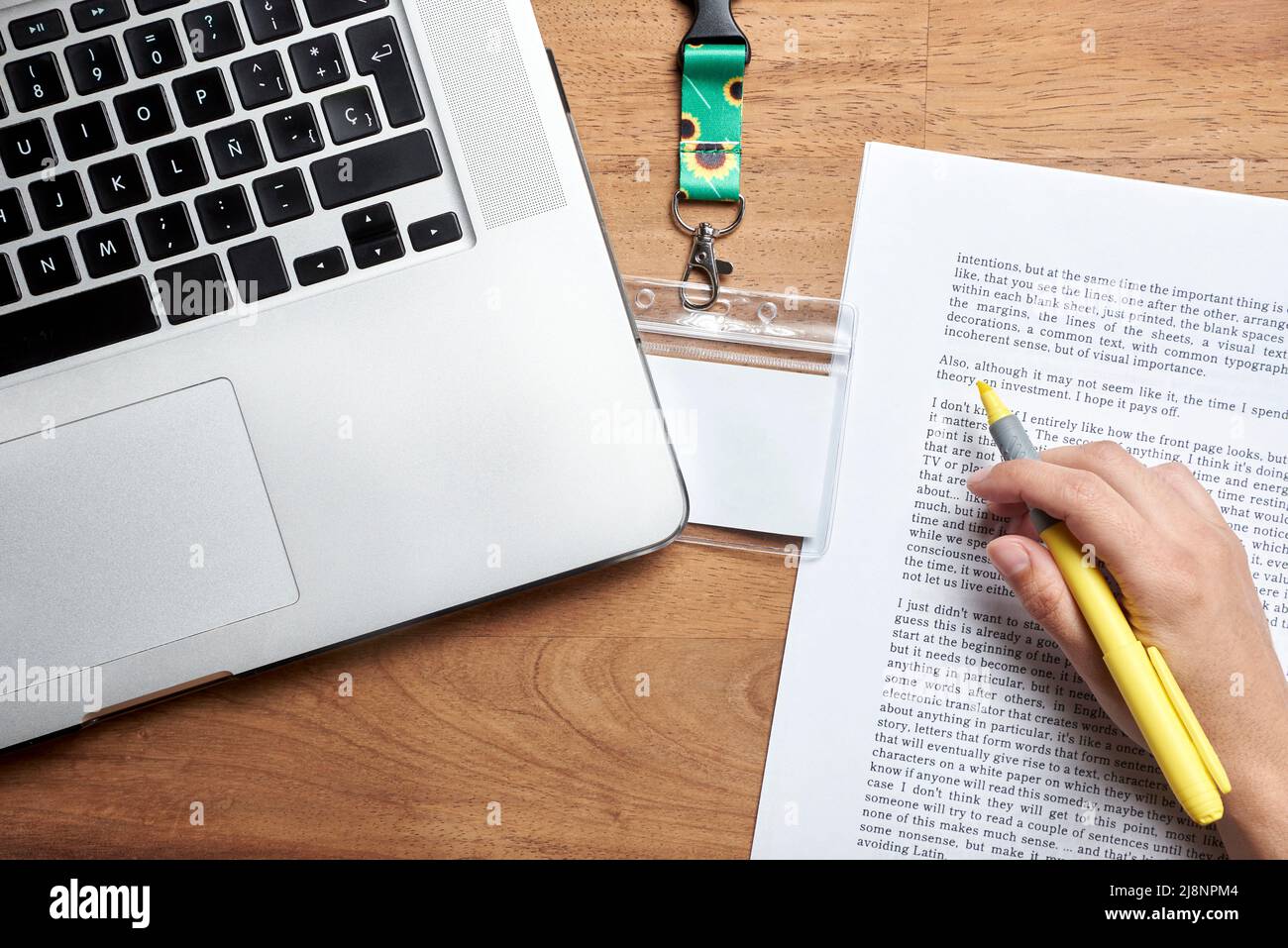 Ansicht von oben auf einen Schreibtisch, ein leerer Personalausweis mit einer Trageschlaufe aus Sonnenblumen, Symbol für Menschen mit unsichtbaren oder versteckten Behinderungen; eine unbekannte Person Studie Stockfoto