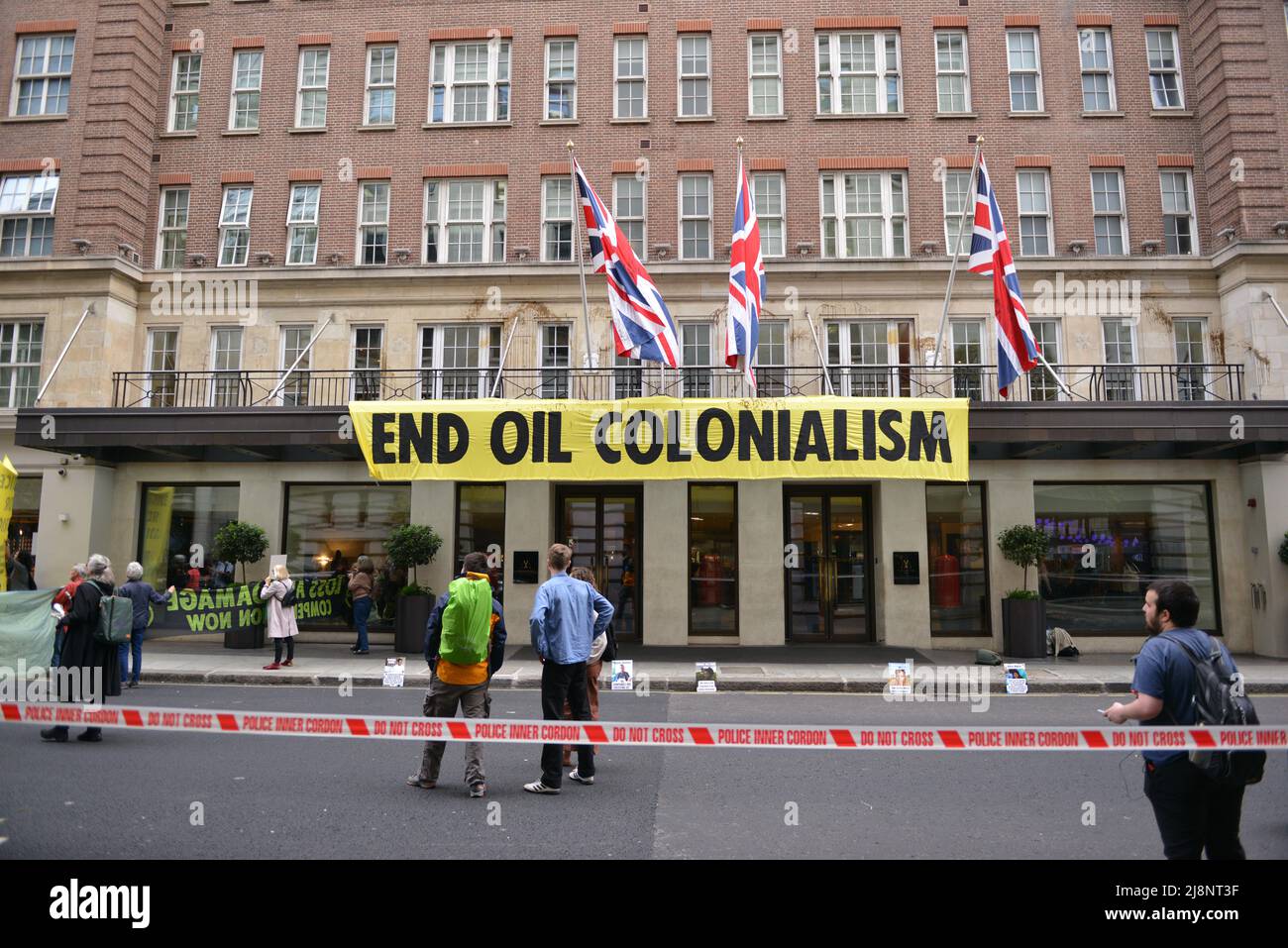 Aktivisten entrollten ein Banner mit der Aufschrift End Oil Colonialism. Aktivisten des Extinction Rebellion stürmen das May Fair Hotel im Zentrum von London aus Protest gegen einen Ölgipfel (Africa Energies Summit), der im fünf-Sterne-Hotel stattfindet. Stockfoto